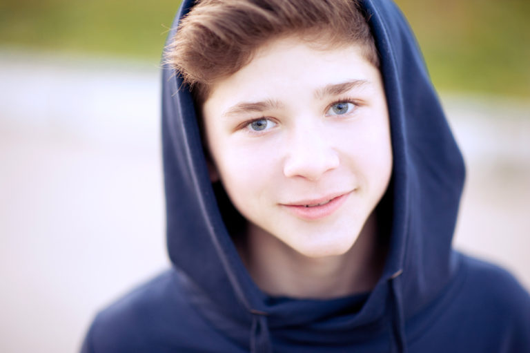 14 year old boy smiling in a hoodie
