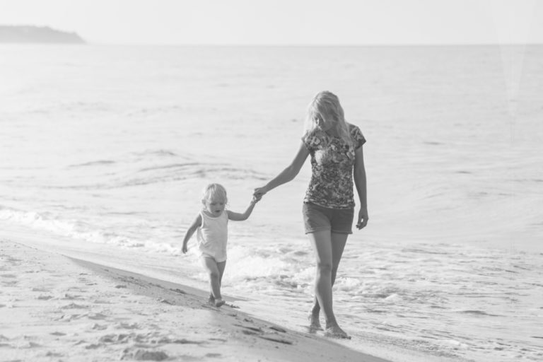 mother daughter walking on beach