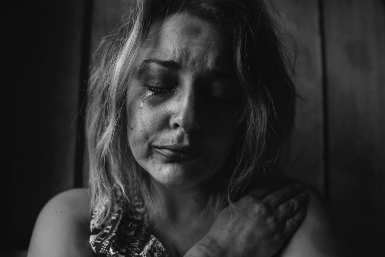 Crying woman in black and white portrait grieving
