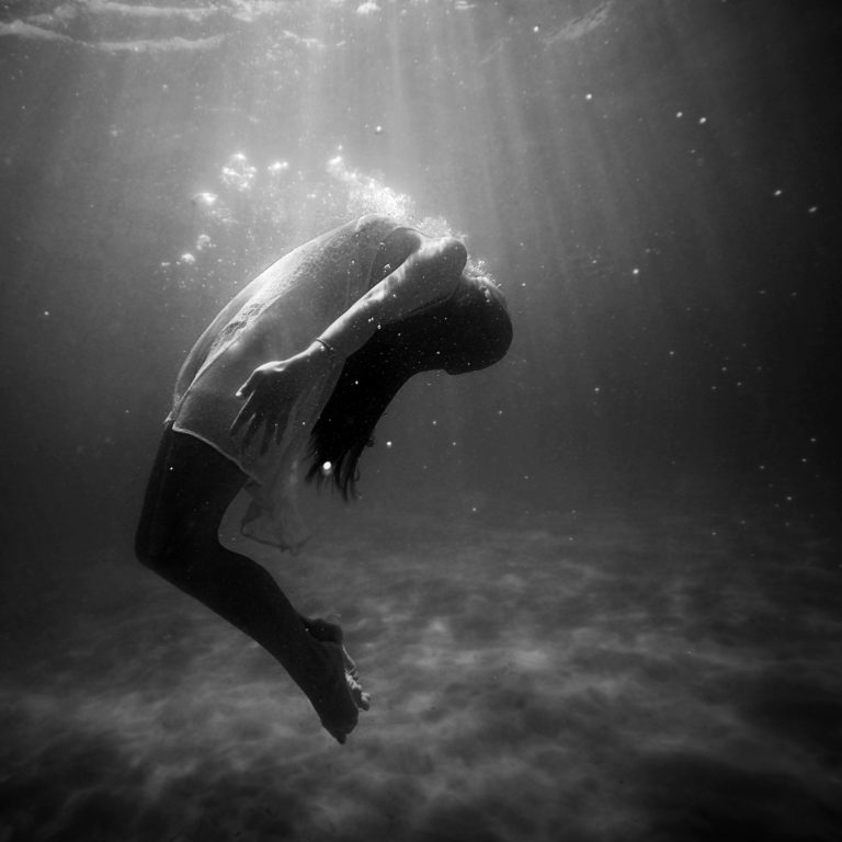 Black and white profile image of woman underwater