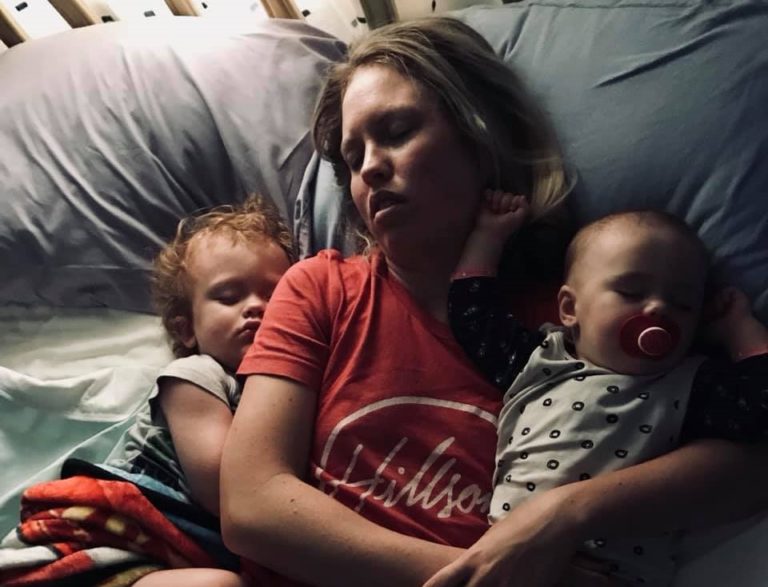Mother sleeping with small children in her arms