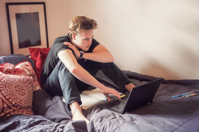 College freshman studying in dorm room on computer
