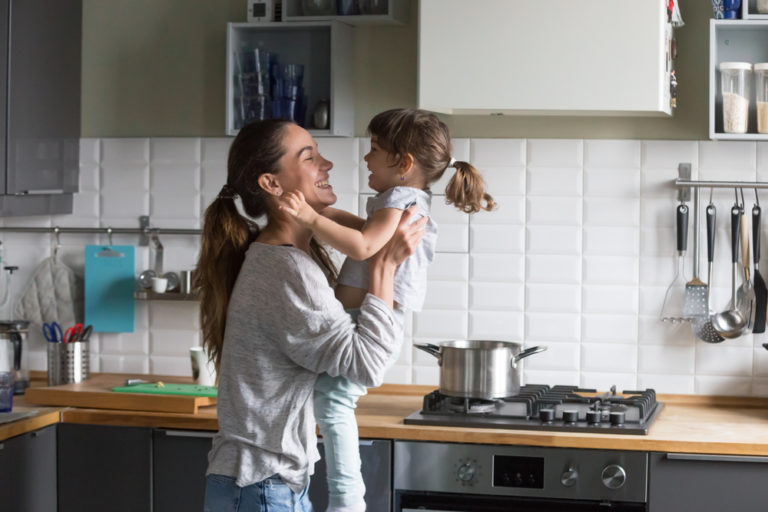 Mother and child in the kitchen laughing at home