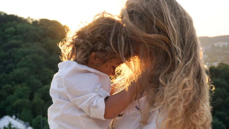 Mother and son touching foreheads in the sunset