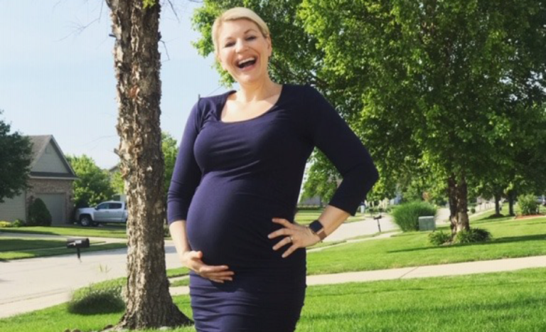 Stacey Skrysak holding pregnant belly and smiling
