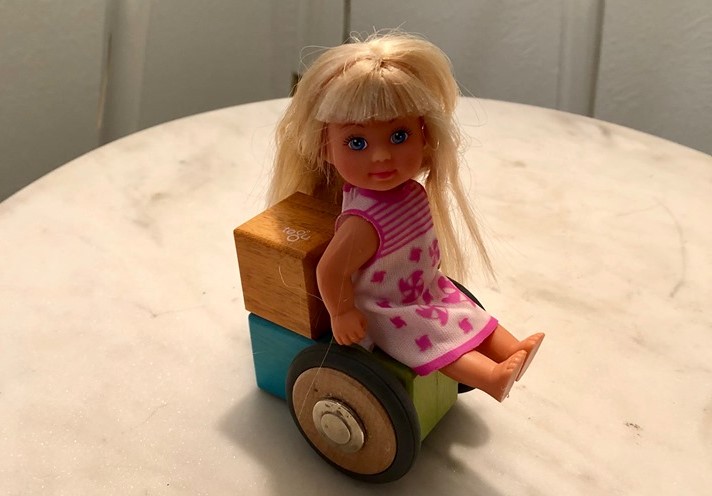 Barbie sitting in a toy wheelchair