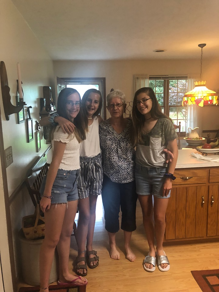 Teens and grandma standing in kitchen