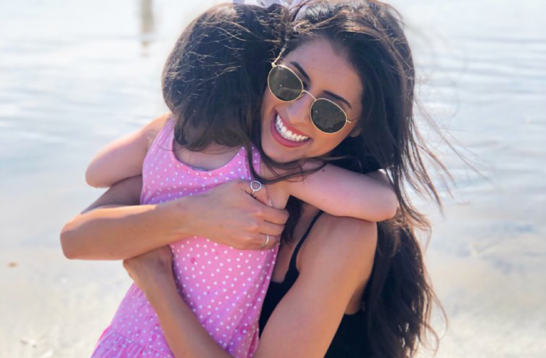 Woman hugging little girl at the beach