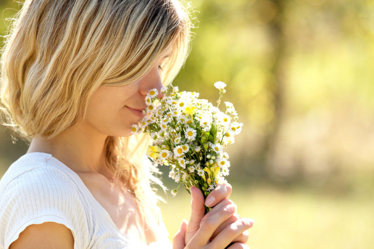 Woman smelling bunch of flowers