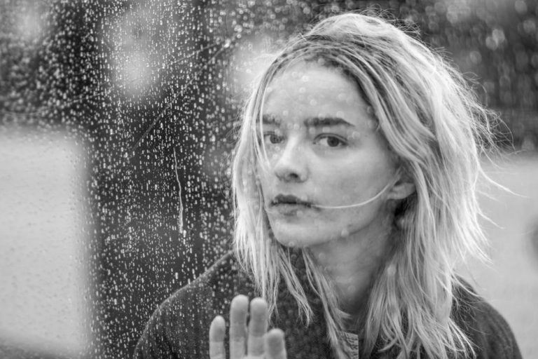 Woman in window with rain