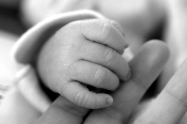 Baby hand grasping mother's finger