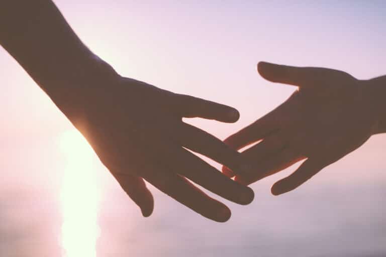 Hands touching in sunset