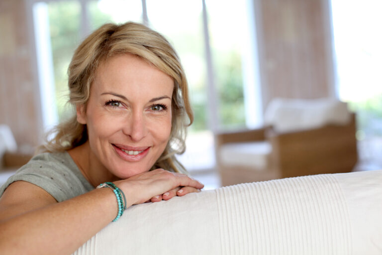 middle aged woman smiling on couch