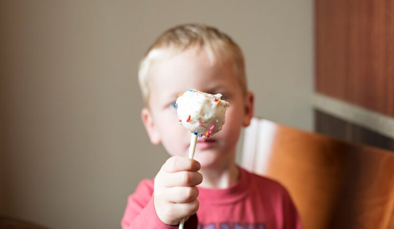 Little boy holding cake pop, color photo