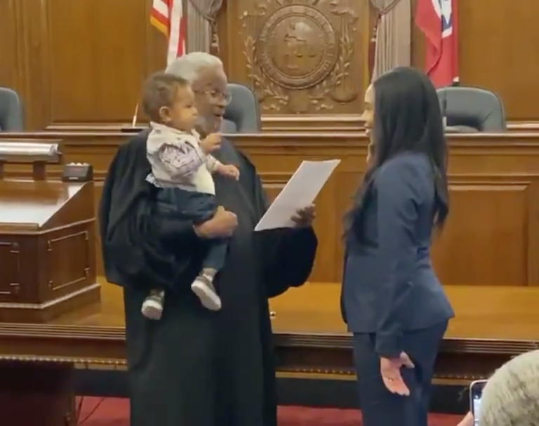 Judge holding baby swearing in lawyer