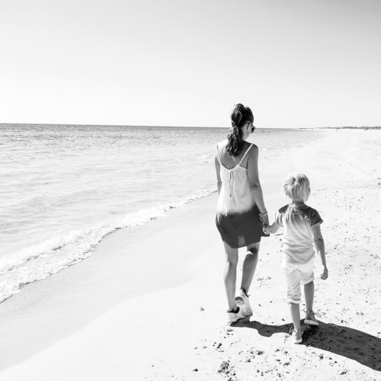 Mom and child walking on beach