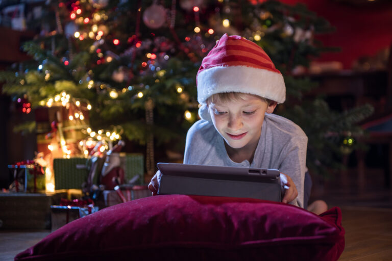 Boy with tablet under the tree