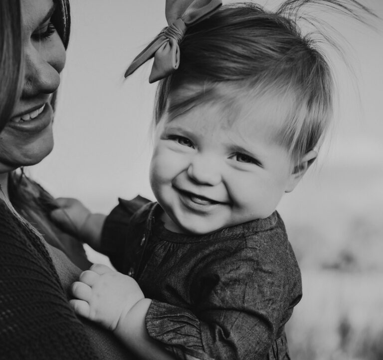 Mother holding smiling toddler girl