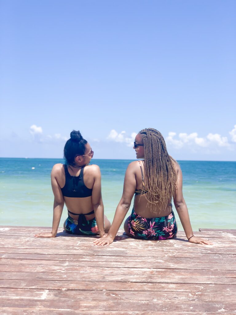 Two women sitting on the pier at the beach, color photo