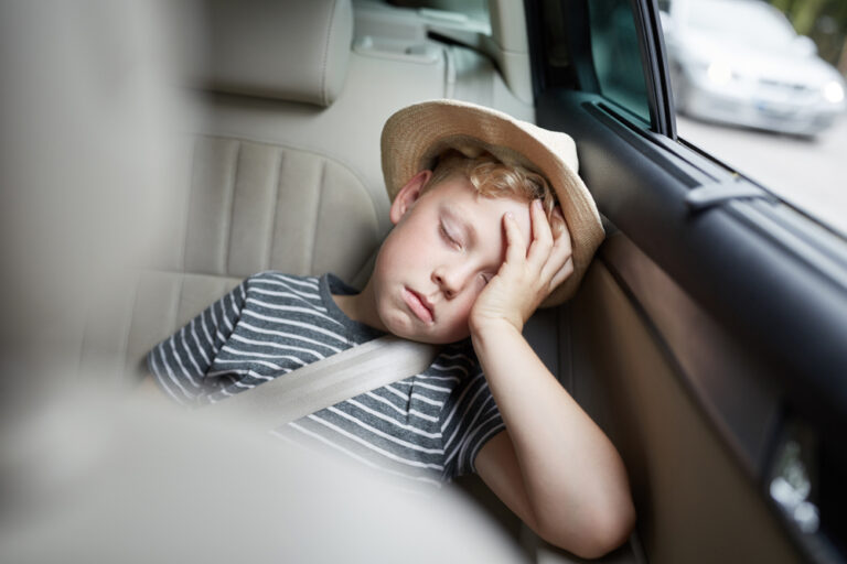 little boy in backseat of car asleep