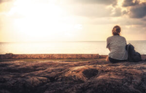 Woman sitting alone beach