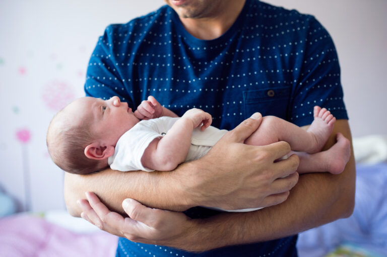 Man holds newborn baby
