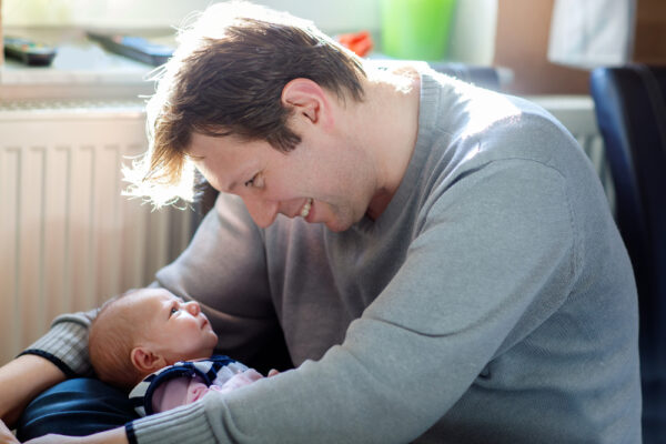 Dad smiling at newborn baby