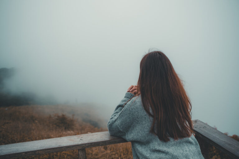 Woman looking over foggy scene