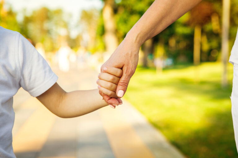 Child and woman holding hands walking