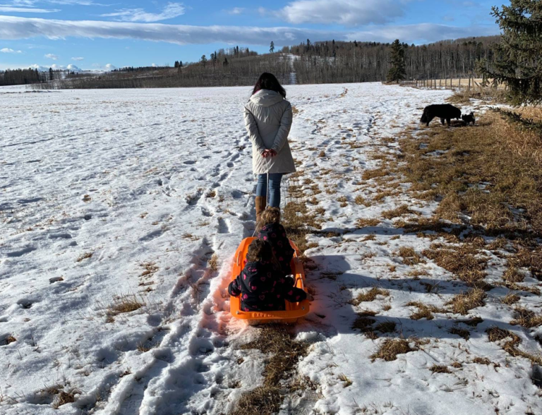 Mother pulling sled with kids