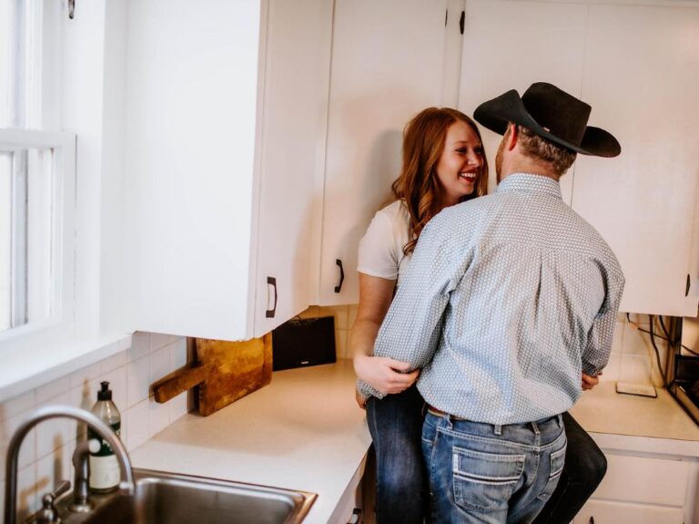 Husband and wife embracing in kitchen