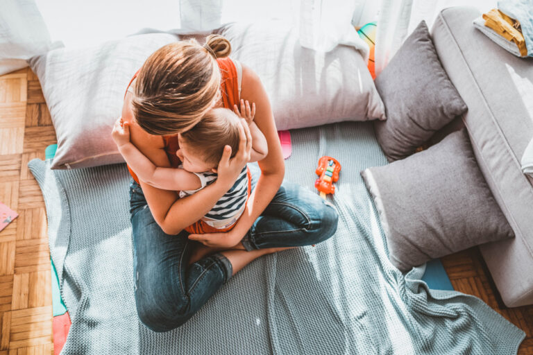 Mother hugging child in living room