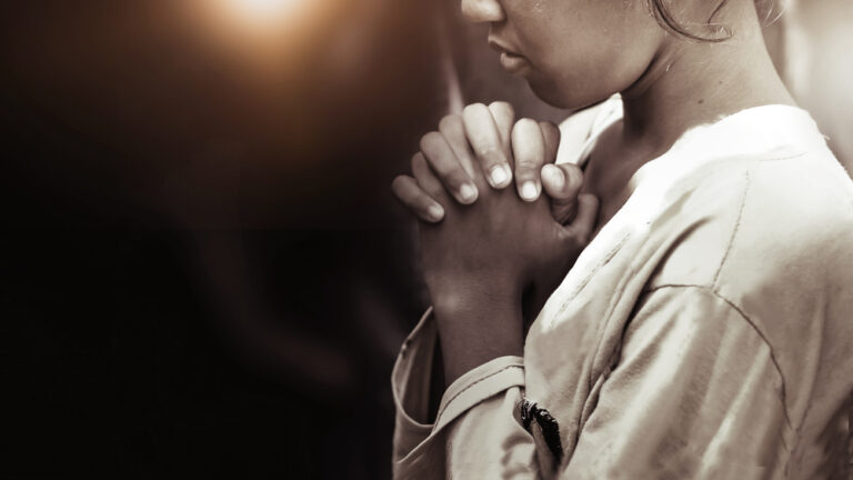 Woman hands clasped in prayer