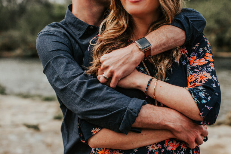 Husband with arms wrapped around wife, color photo