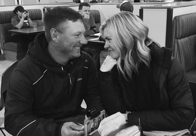 Husband and wife smiling at restaurant, black-and-white photo