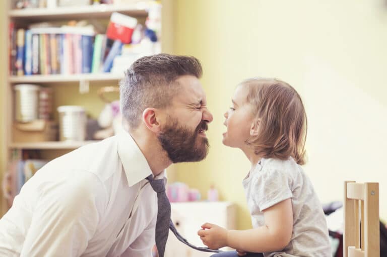 Dad and toddler making faces at each other