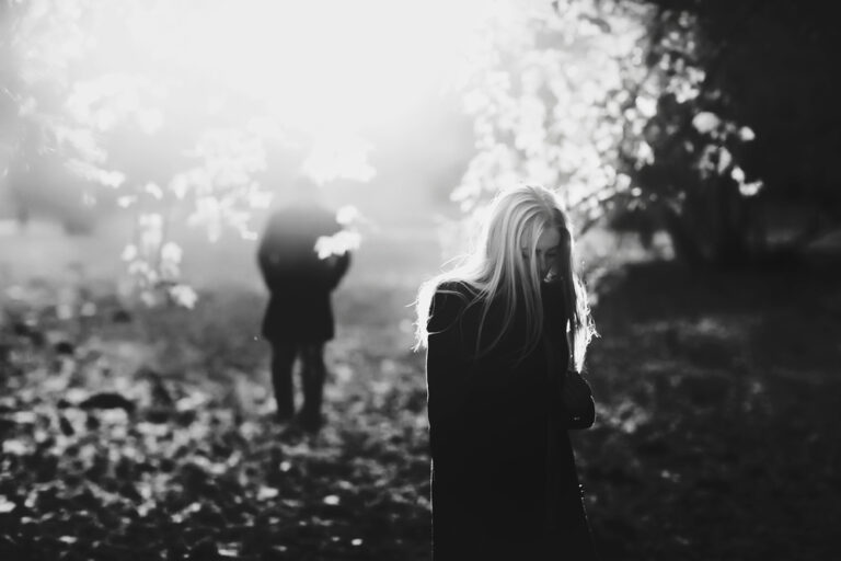 black and white photo of women sad in forest