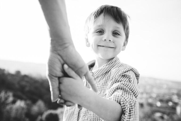 Little boy holding mother's hand, black and white photo