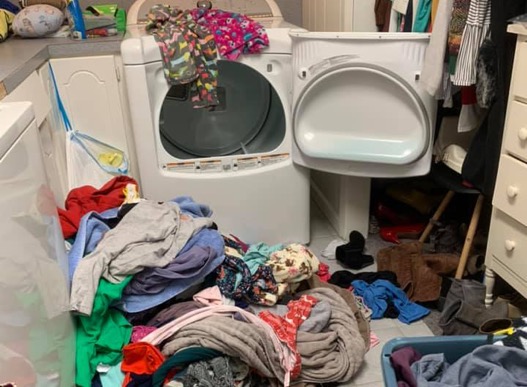 Laundry piled up by washing machine