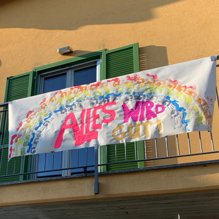 Banner hanging on balcony in Italy with rainbow