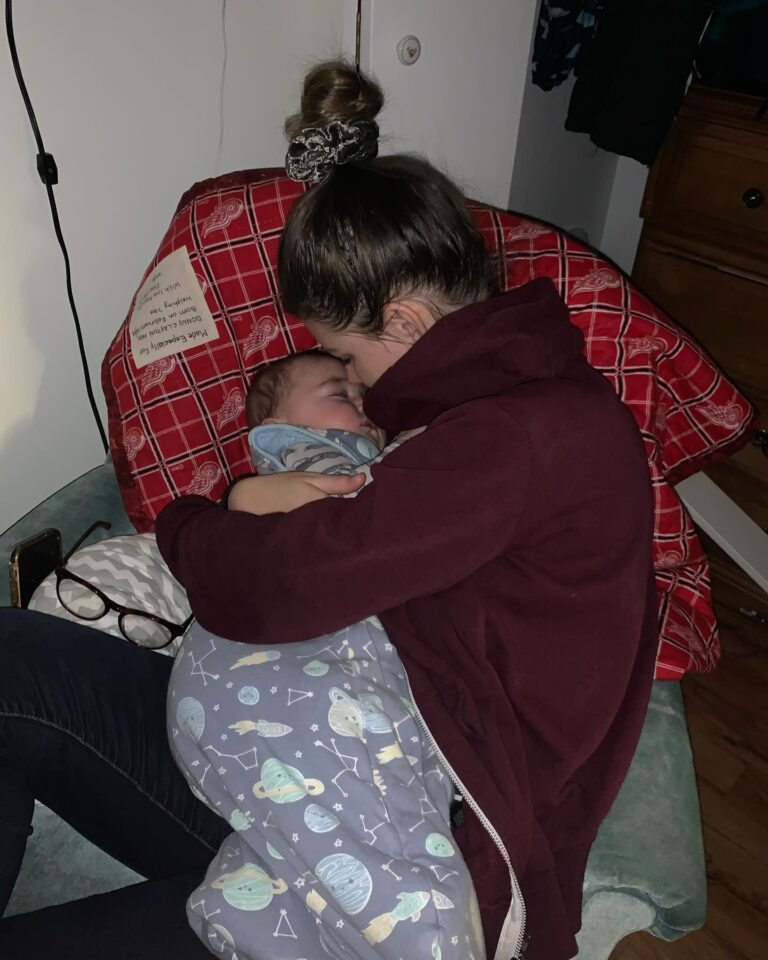 Mom holding sleeping baby, color photo