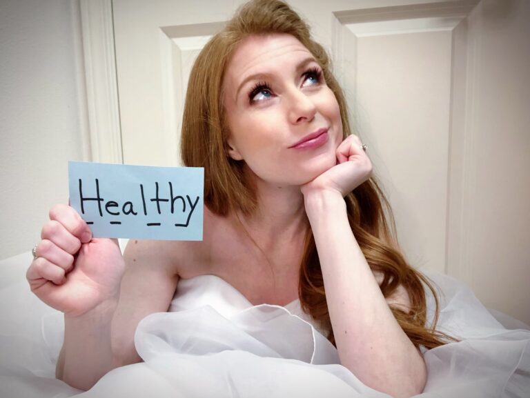 Woman in wedding dress holding paper that reads "healthy," color photo