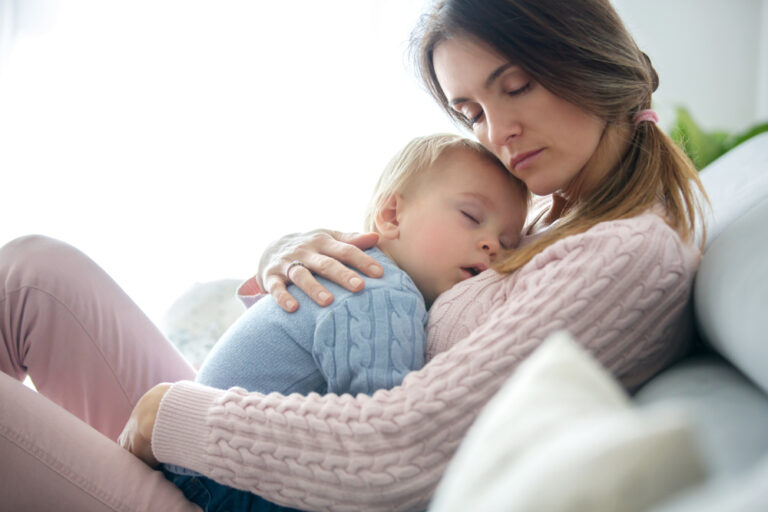 Mother holding sleeping toddler on chest