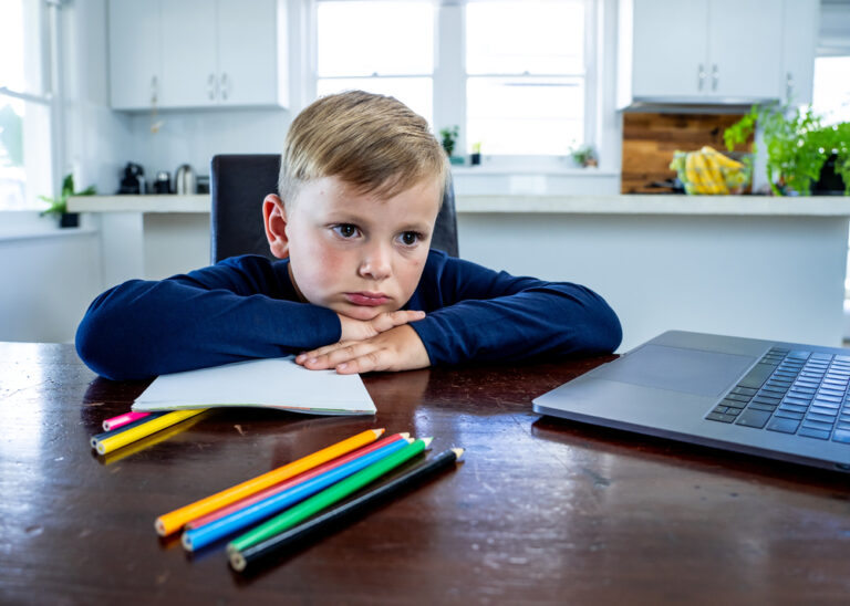 Disappointed little boy at kitchen table