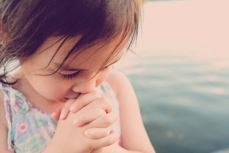 Little girl bowed in prayer