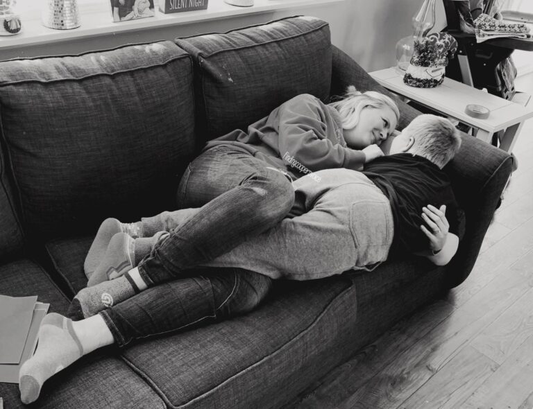 Mother and son lying on couch, black-and-white photo