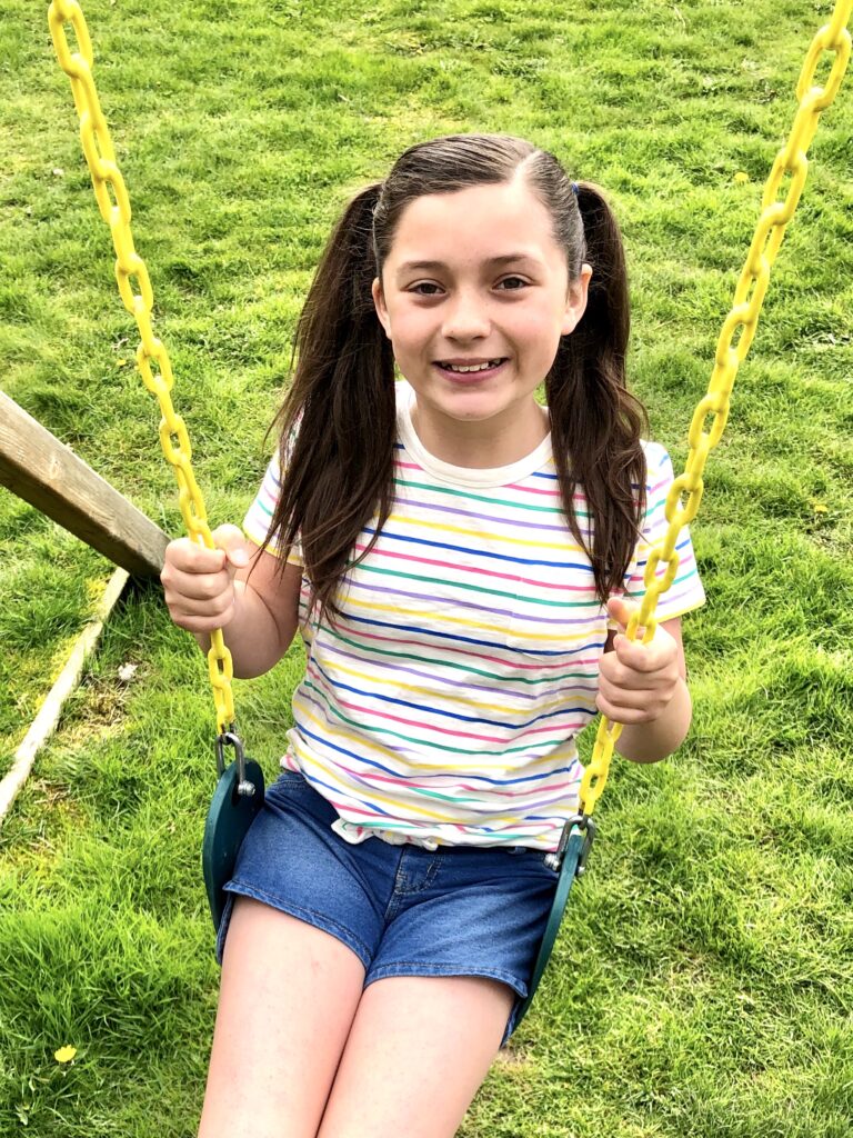 Little girl with pigtails swinging
