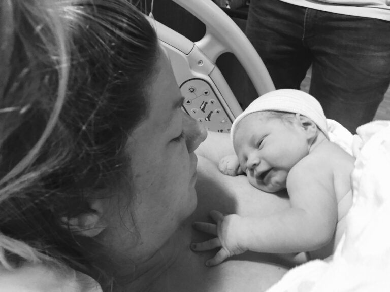 Mother with newborn in hospital room, black-and-white photo