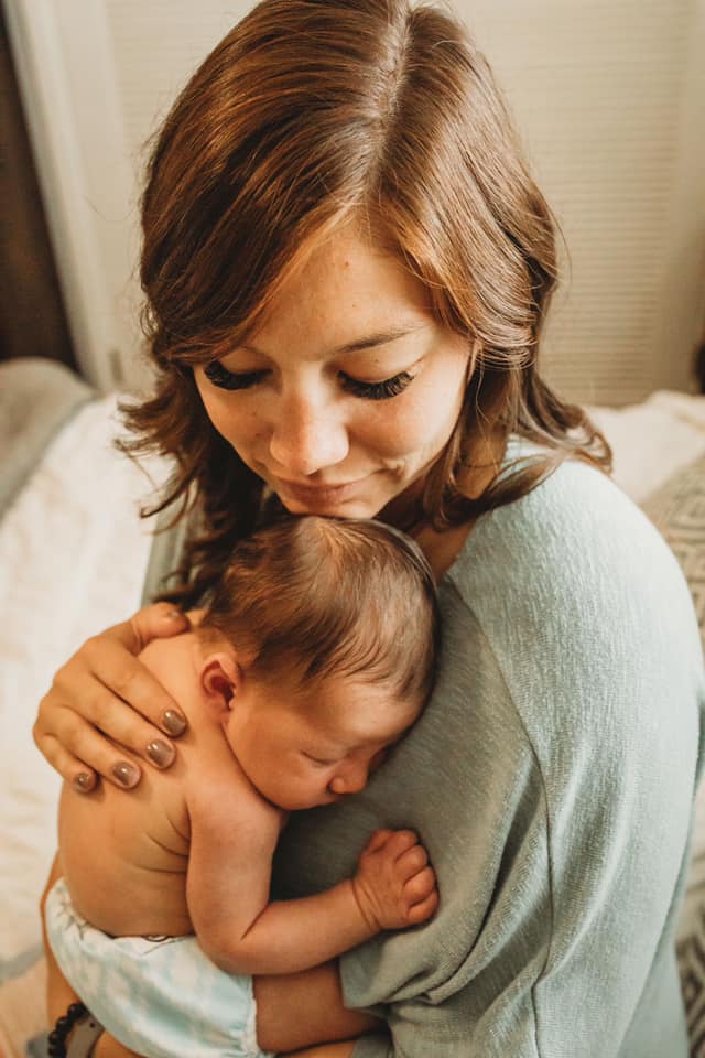 Mother holding newborn, color photo