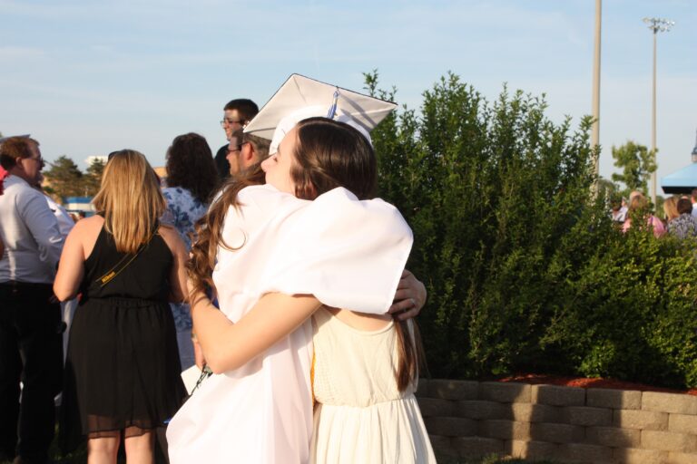 High school graduate hugging sister